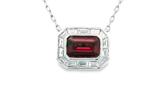 a white gold pendant necklace featuring a large red garnet and diamond accents