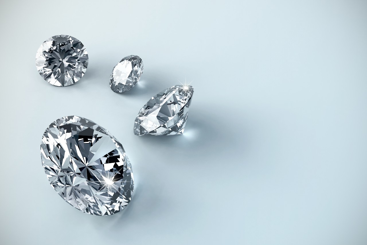 close up image of four round cut diamonds on a gray surface