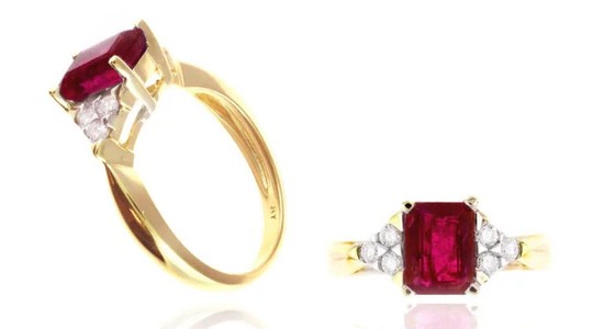 a yellow gold fashion ring with an emerald cut ruby and diamond side stones