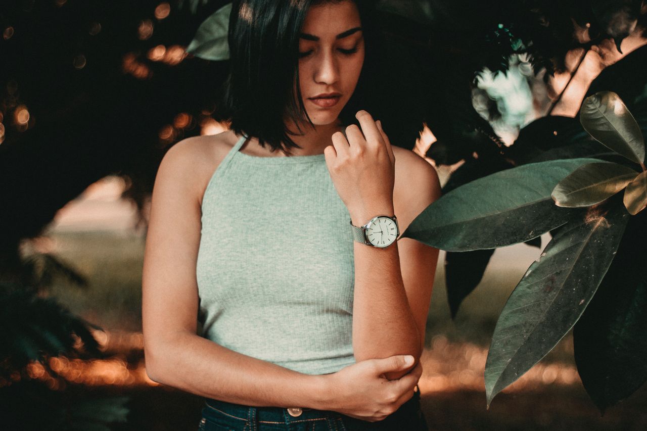A casually dressed young woman wearing an elegant wristwatch.