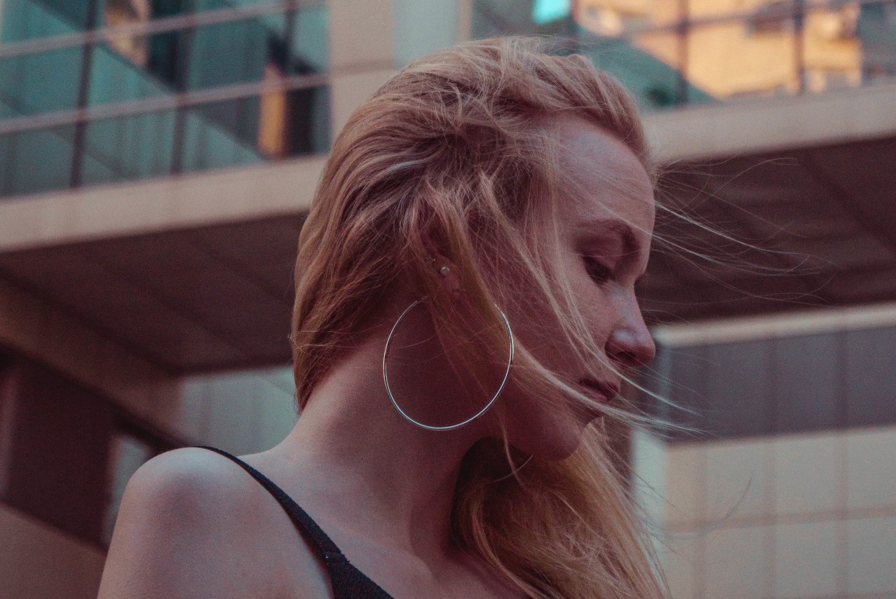 a woman looking away from the camera and wearing large hoop earrings