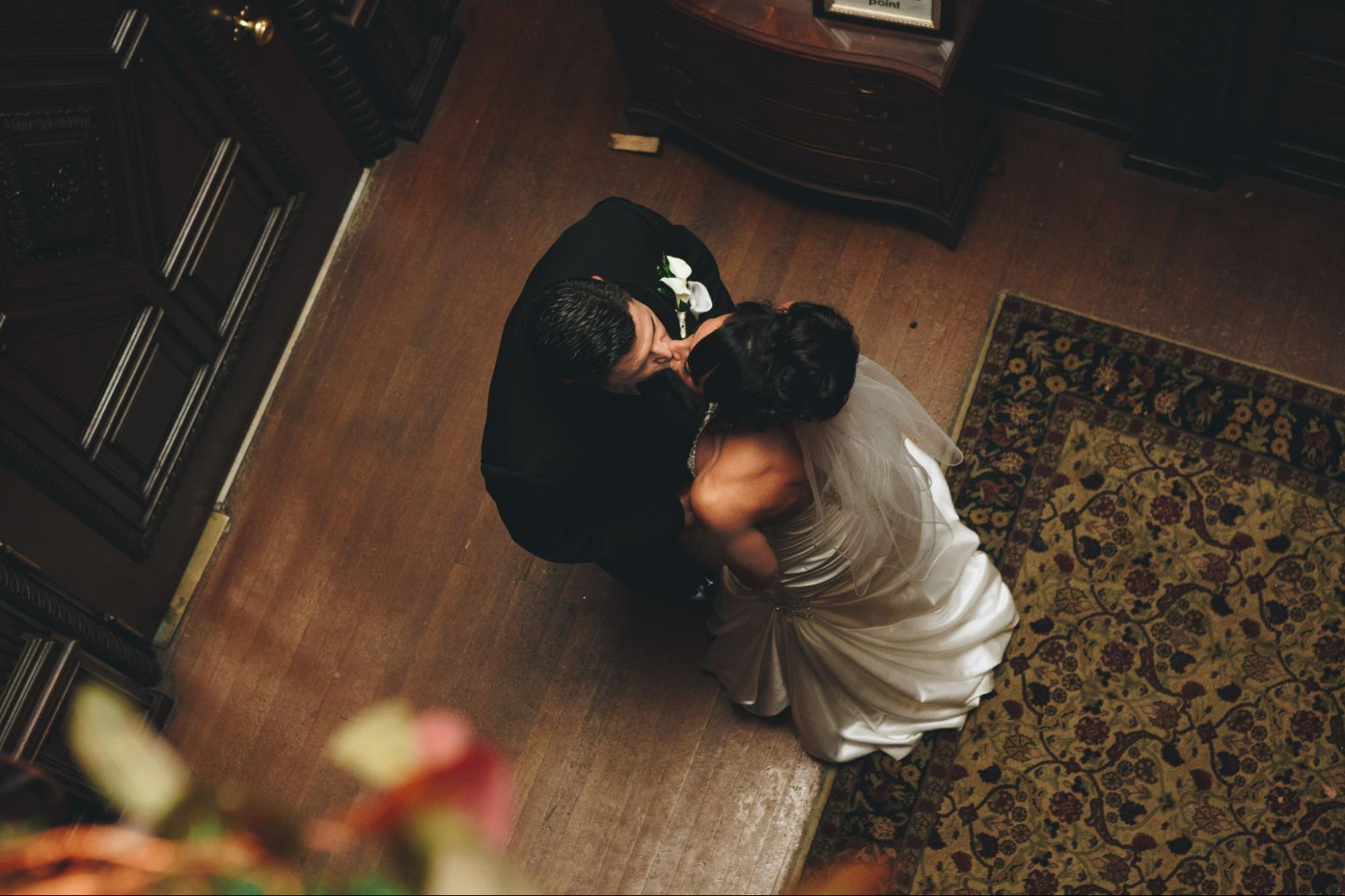 A bride and groom share a private kiss before entering their reception.