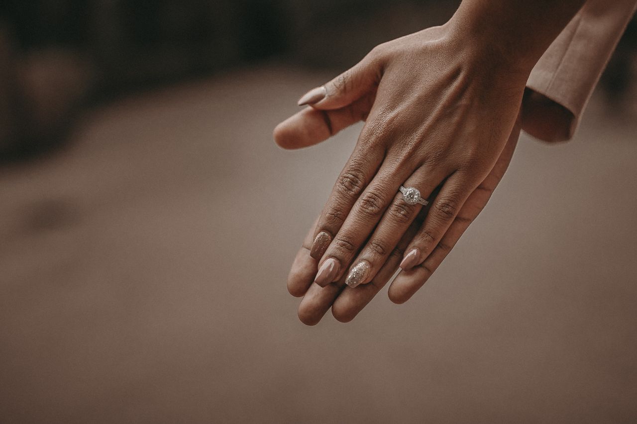 A close-up of a bride-to-be’s hands, adorned with an elegant engagement ring.