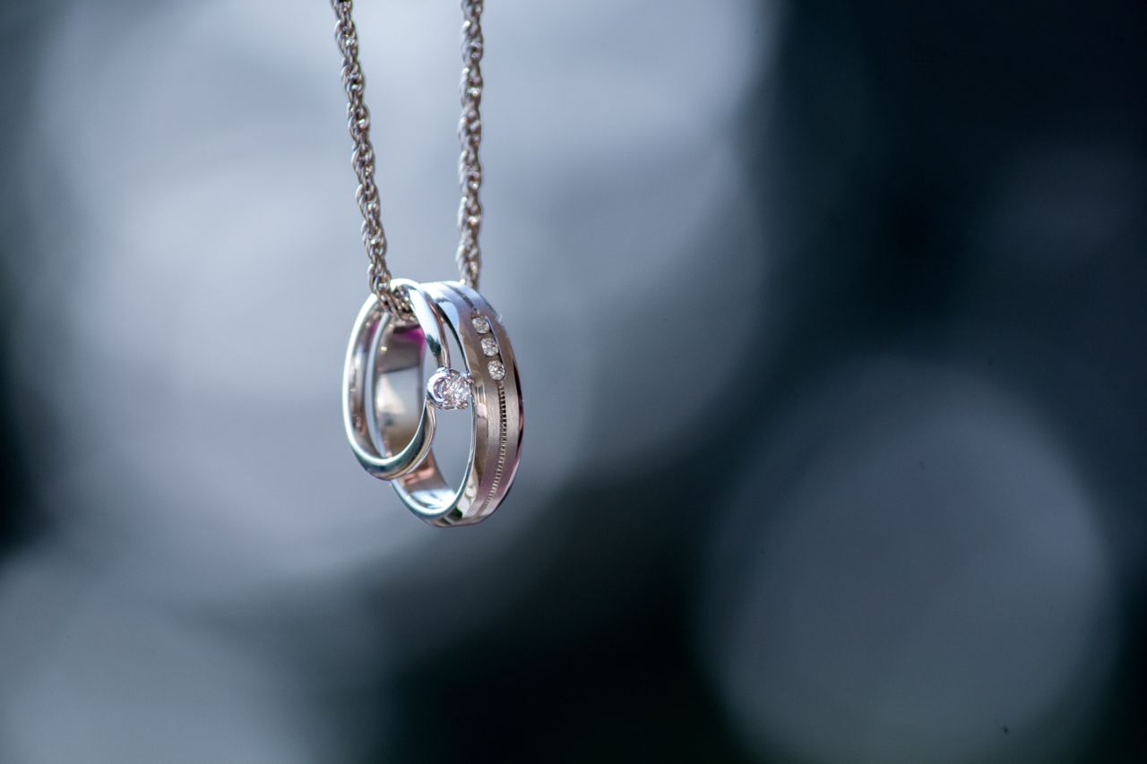 A classic engagement ring and wedding band displayed on an elegant chain.