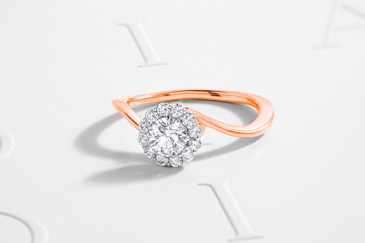 A free-form engagement ring forged of mixed metals and a diamond halo.